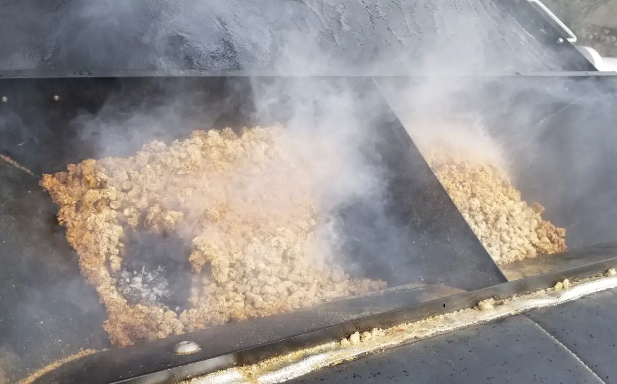 damp wood pellets smoldering in hopper of recteq pellet grill